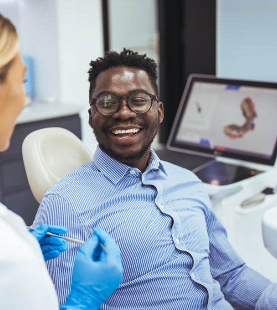 Male dental patient smiling at female dentist