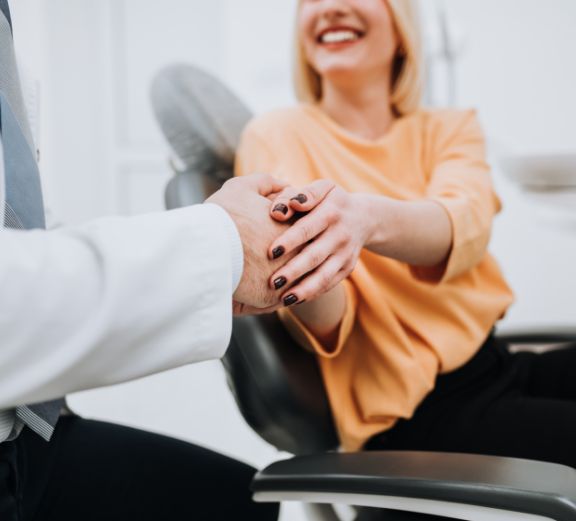 Close up of dentist shaking dental patients hand